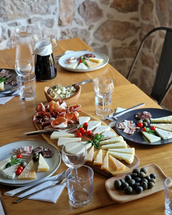 Dalmatinska plata sa sirom, pršutom i maslinama na drvenoj dasci